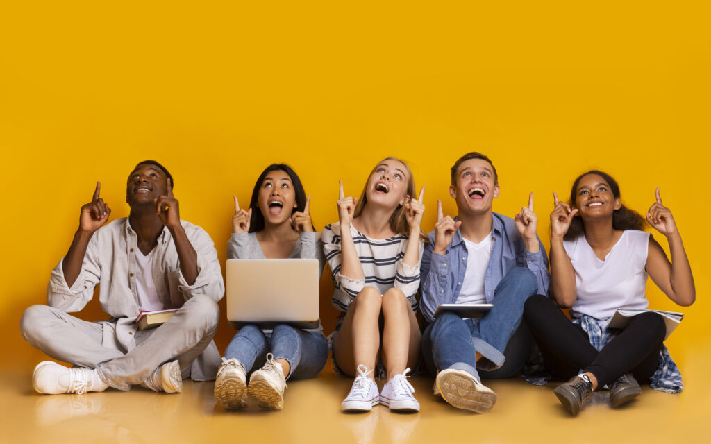 students pointing up at copy space
